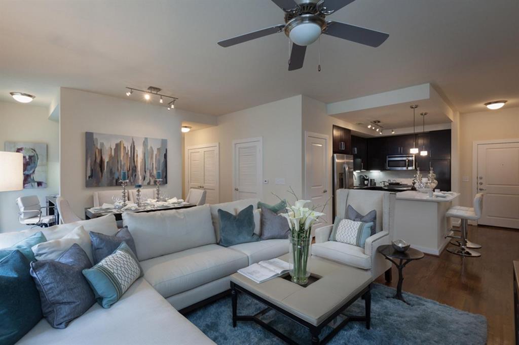 a living room with furniture and a view of kitchen