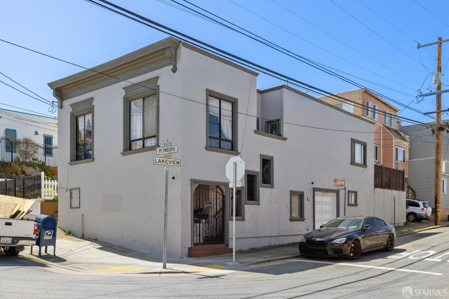 a front view of a building with cars parked