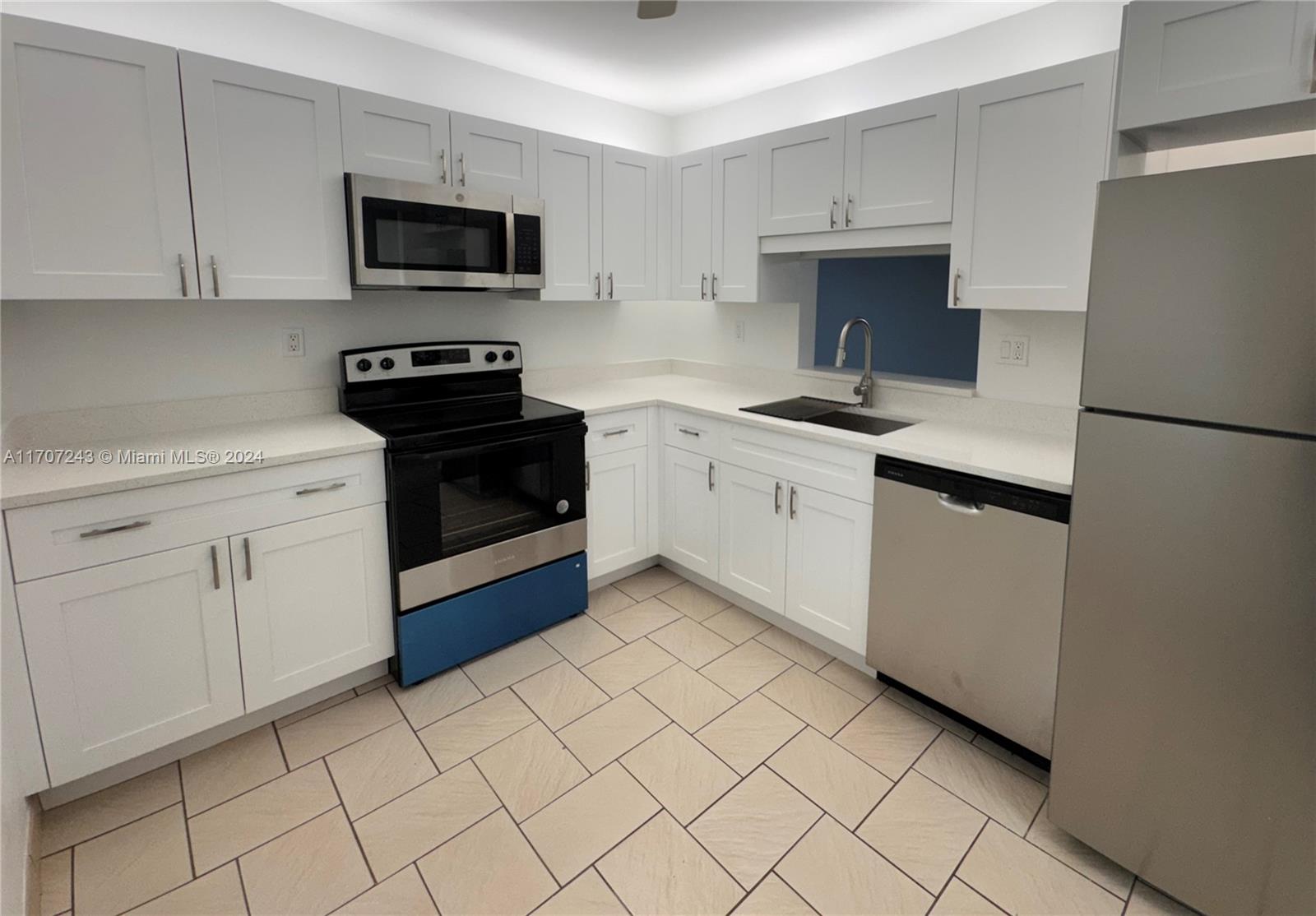 a kitchen with cabinets stainless steel appliances and a sink