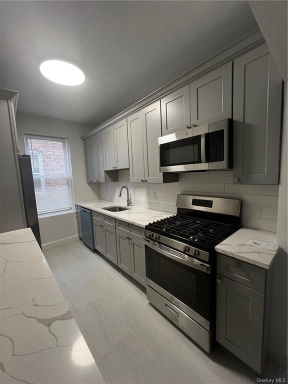 a kitchen with stainless steel appliances granite countertop white cabinets a stove a sink and dishwasher