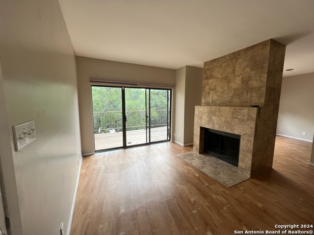 a view of empty room with wooden floor and fireplace