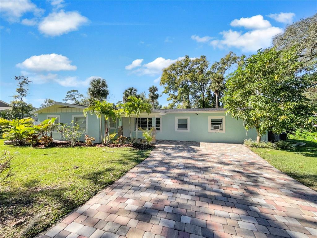 a front view of a house with a yard and trees