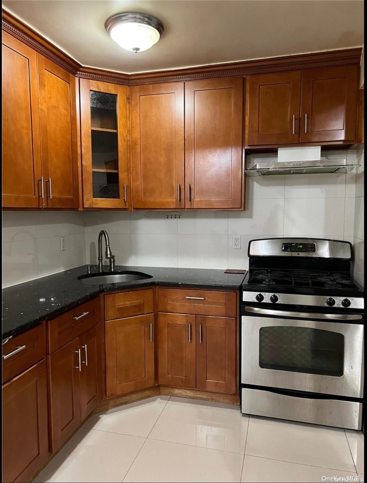 a kitchen with wooden cabinets and a stove top oven