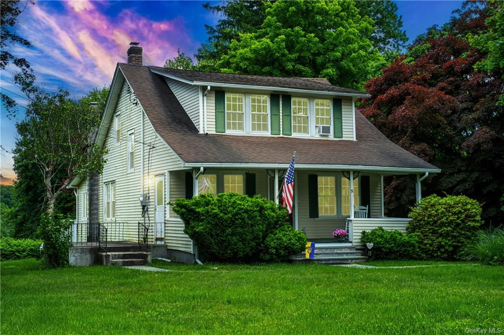 View of front facade with a porch and a yard