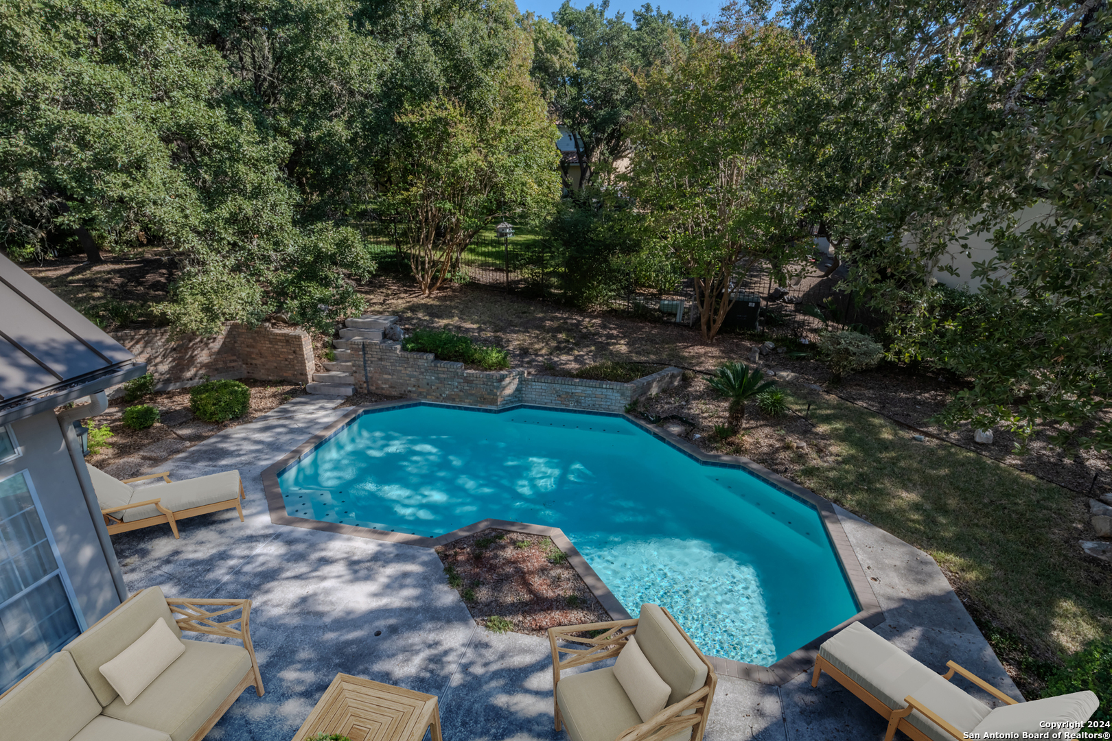 a view of a backyard with plants and a patio