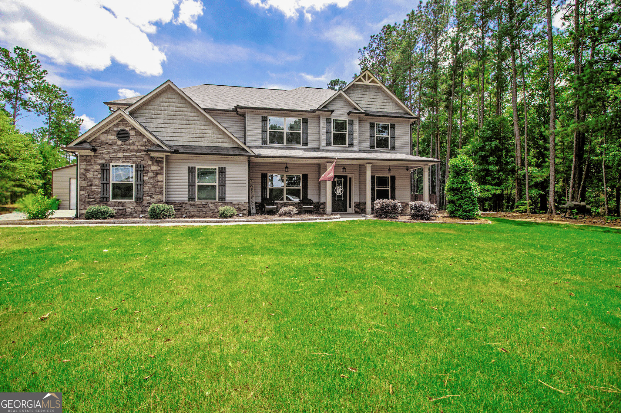 front view of a house with a yard patio and sitting area