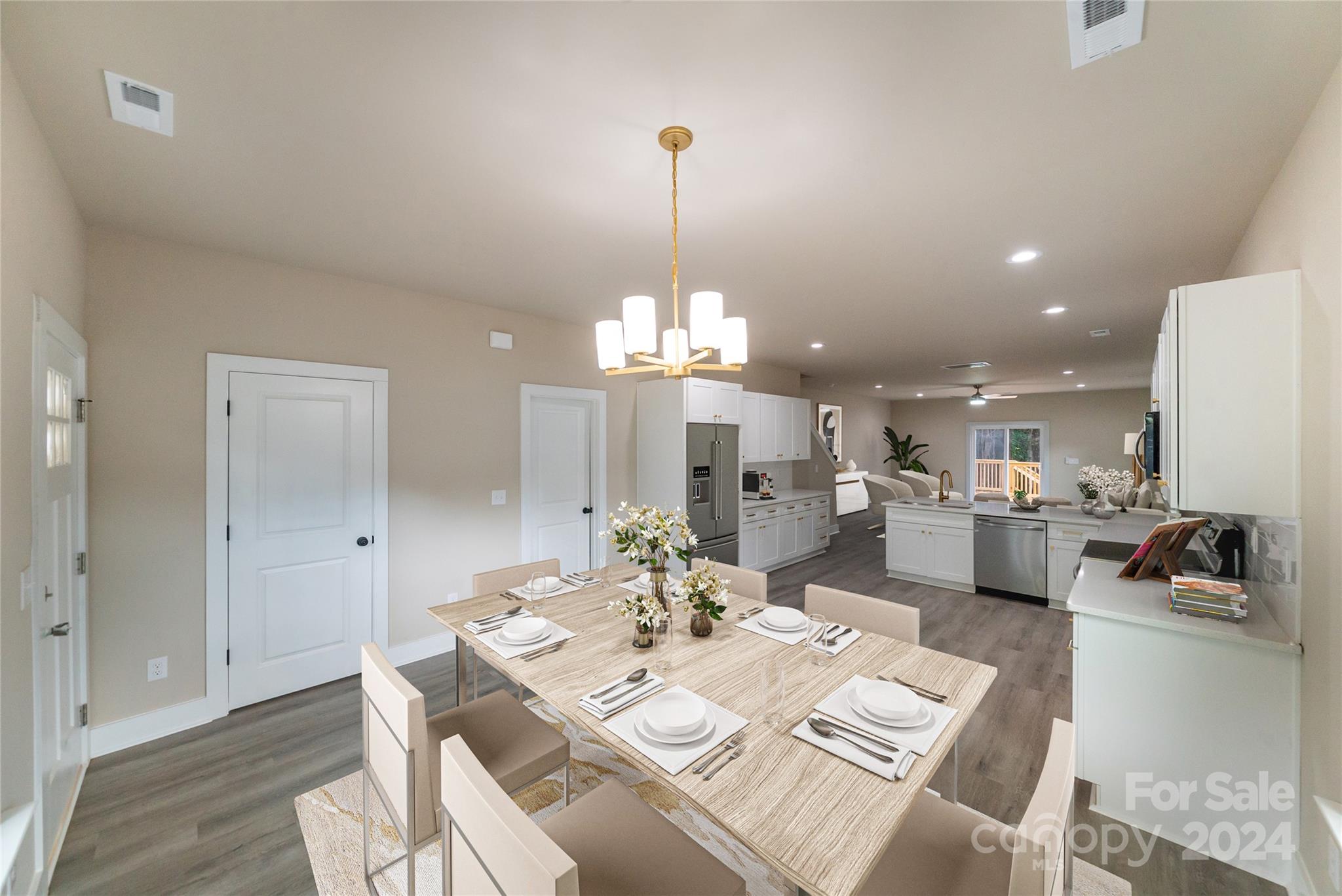 a view of a dining room and livingroom view with furniture wooden floor a chandelier