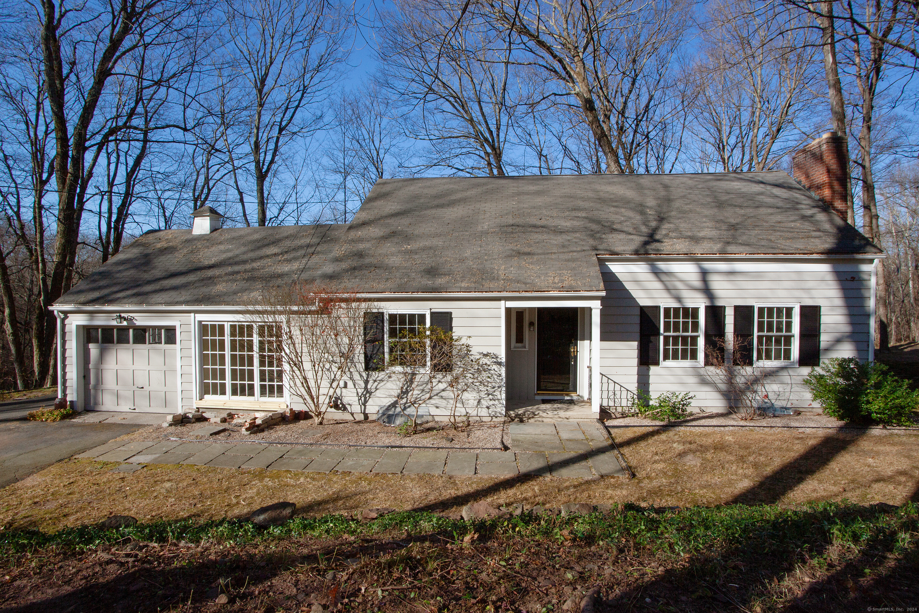 a front view of house with yard and trees around