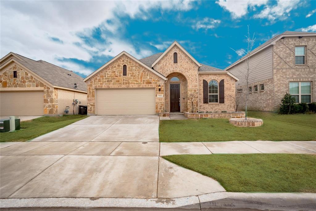 a front view of a house with a yard and garage