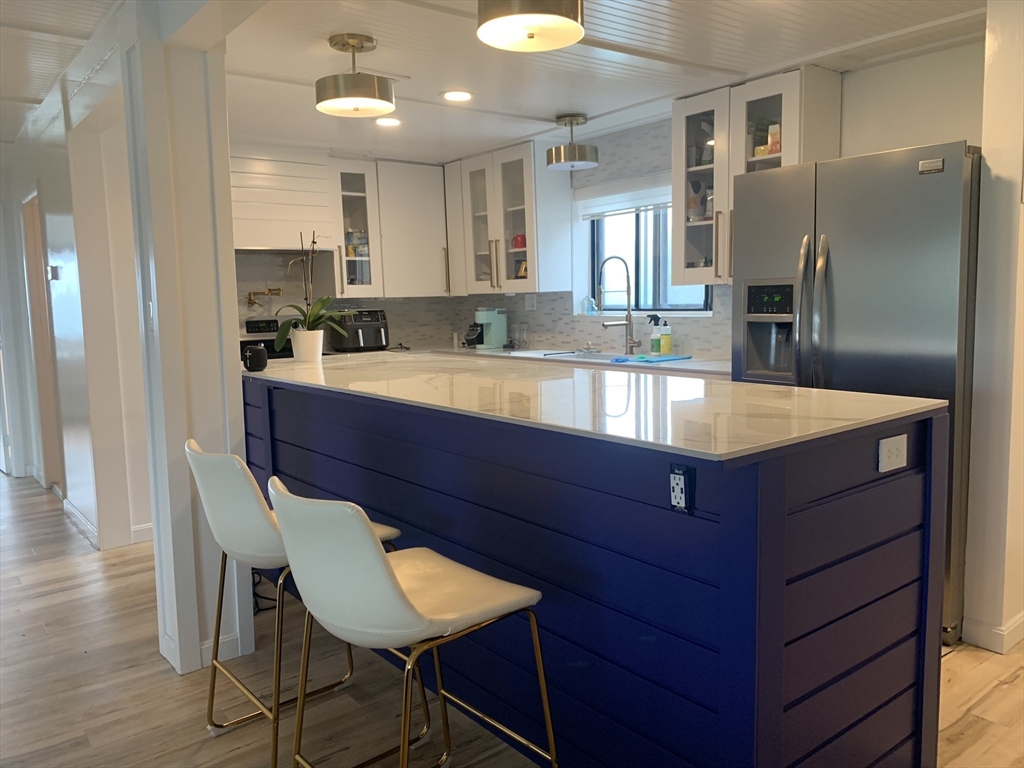 a kitchen with stainless steel appliances granite countertop a refrigerator and a sink