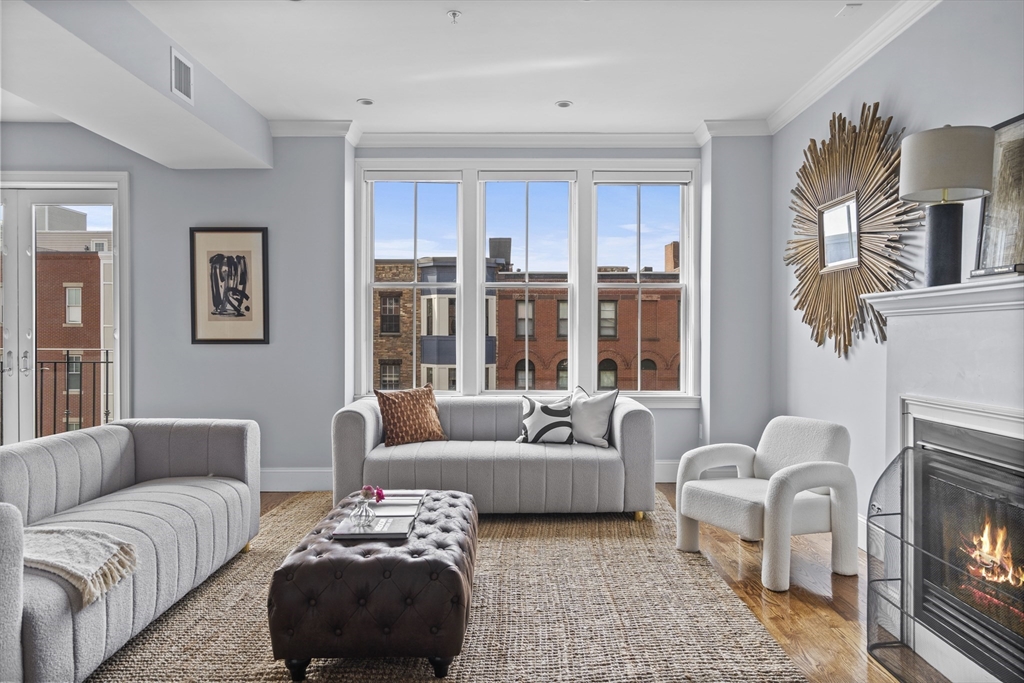 a living room with furniture fireplace and a large window