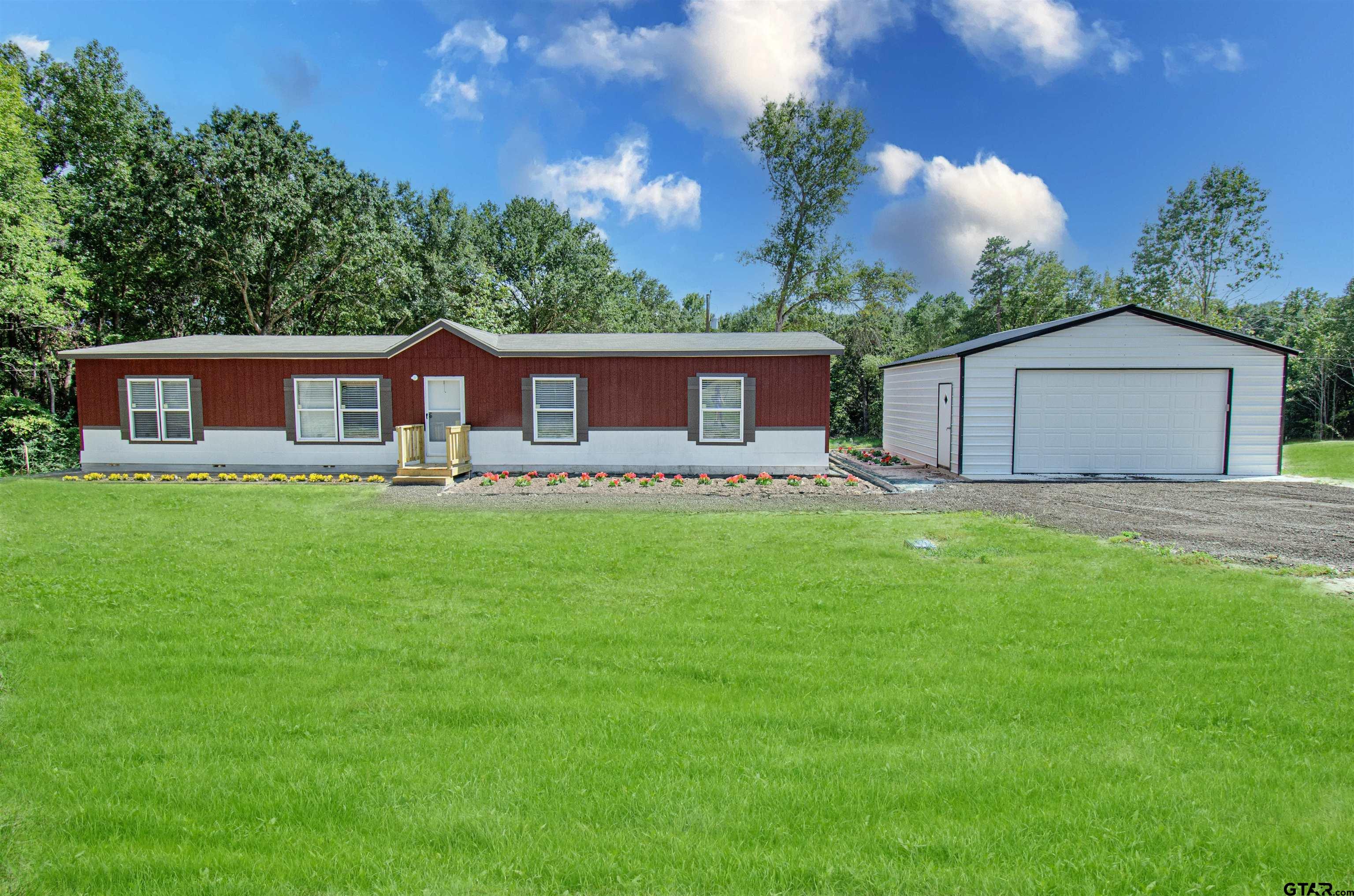 a front view of house with yard and green space