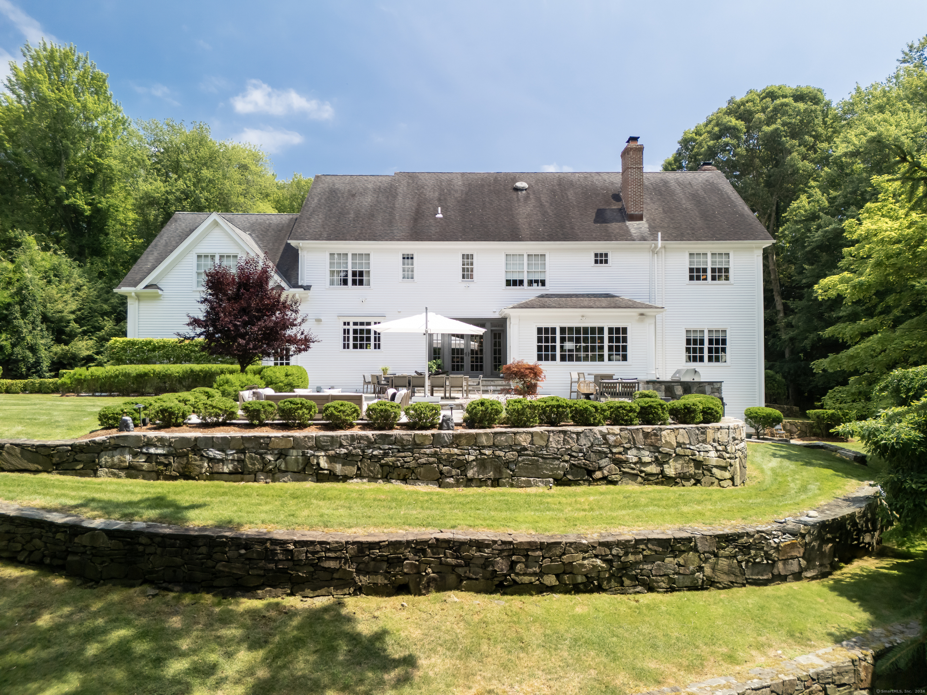 a front view of a house with a garden and lake view