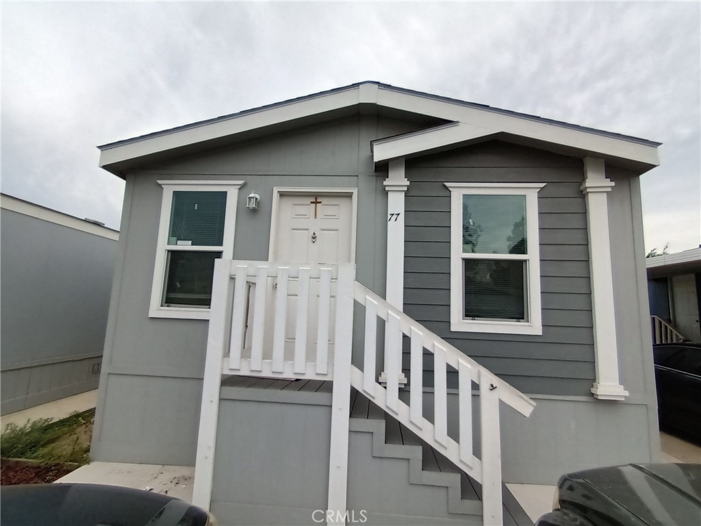 a view of wooden house with a small yard