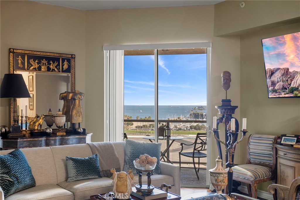 a living room with furniture a floor to ceiling window and a flat screen tv