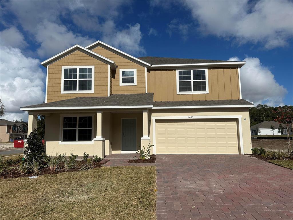 a front view of a house with a yard and garage