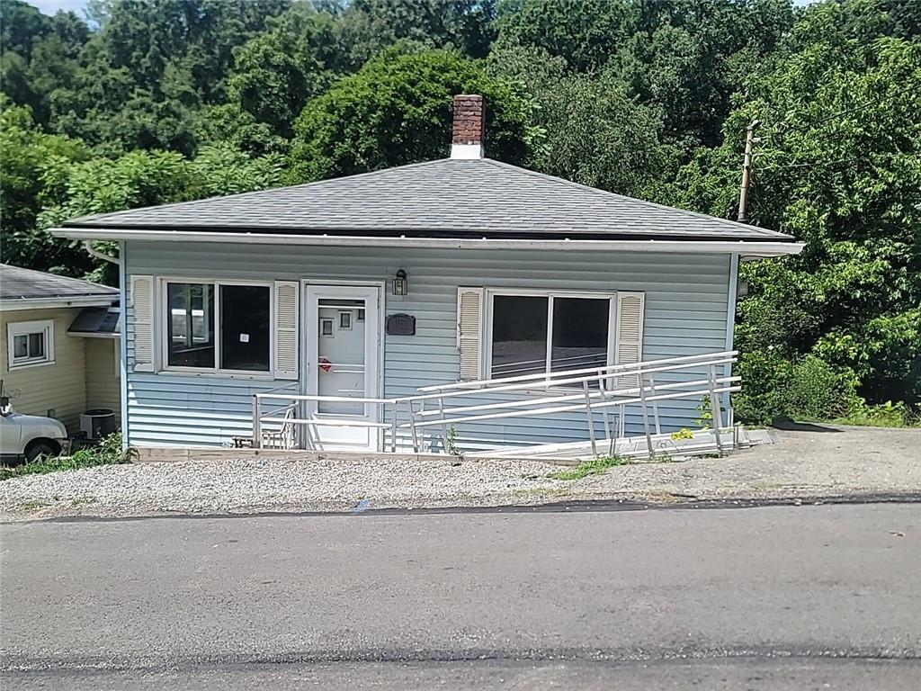 a house that has a large car parked on road