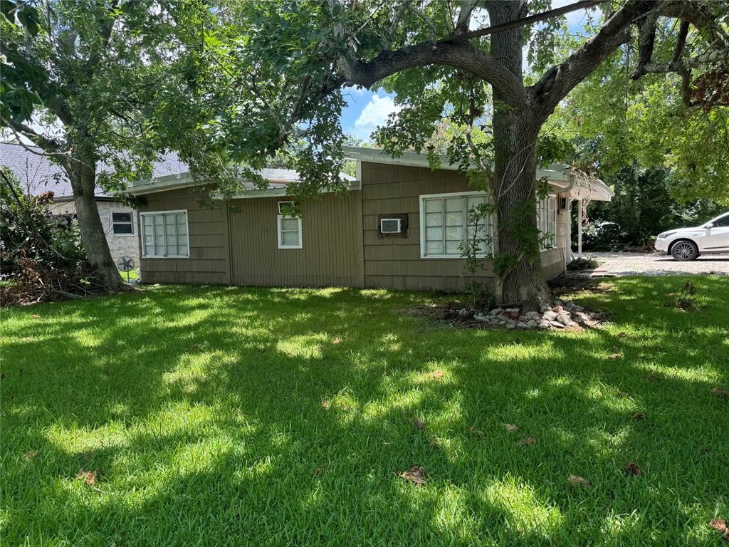 a backyard of a house with large trees and a large tree