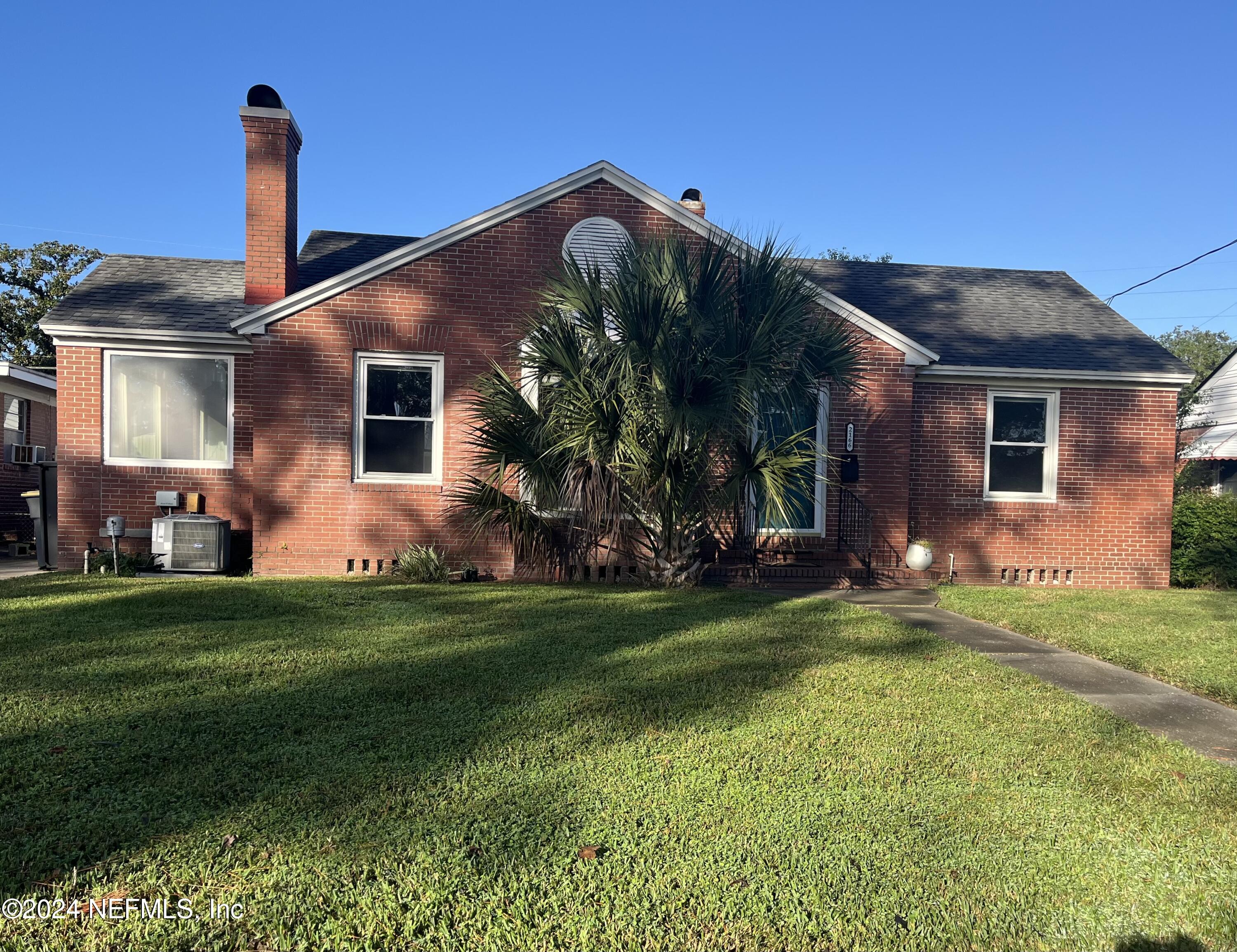 a front view of house with yard and outdoor seating