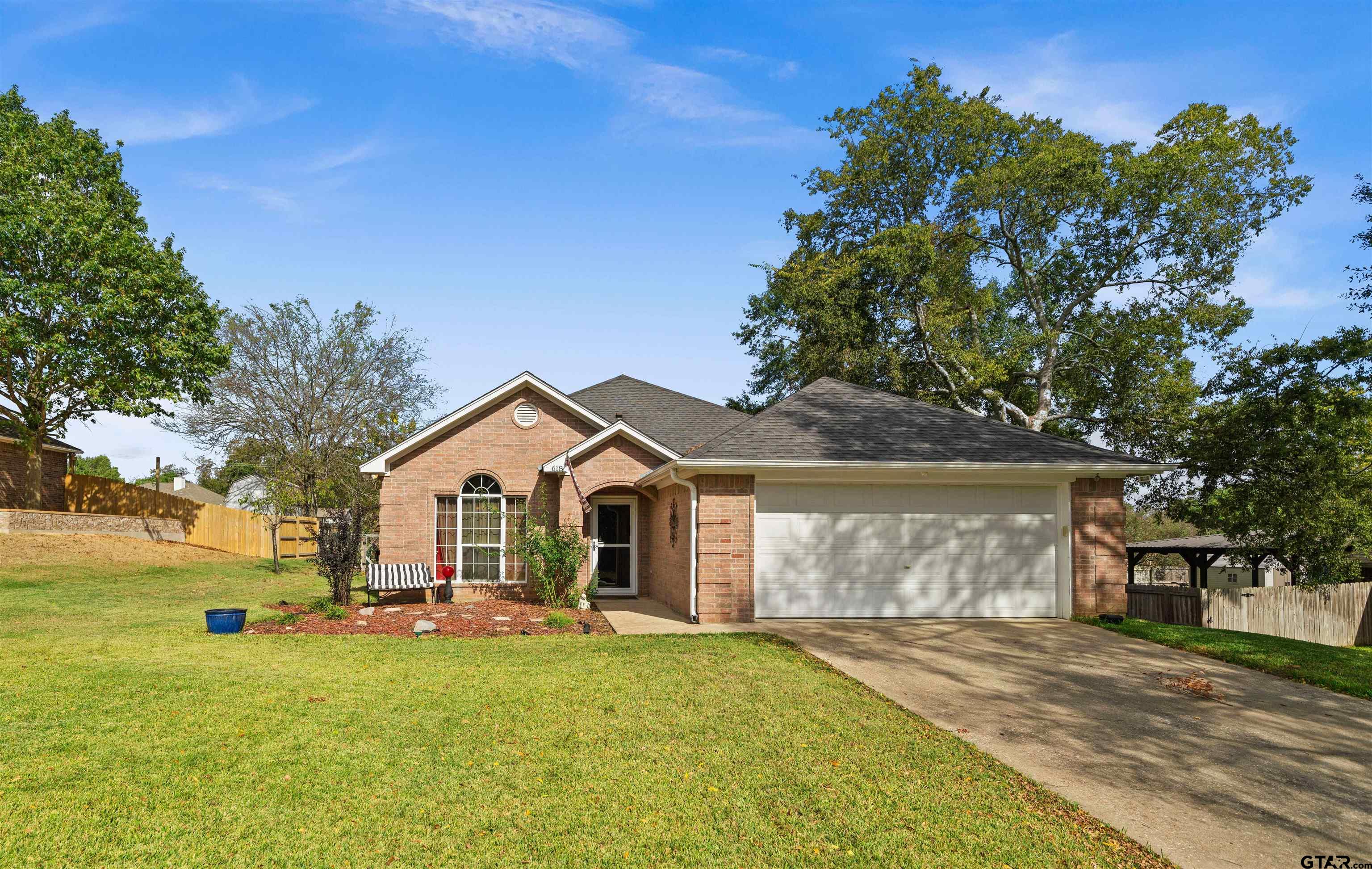 a front view of a house with yard and green space