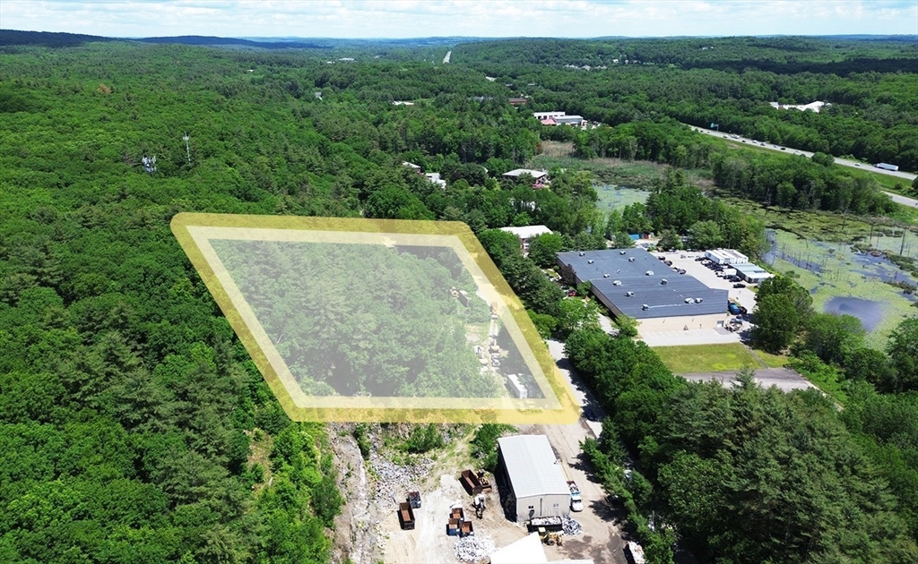 an aerial view of residential houses with outdoor space and trees