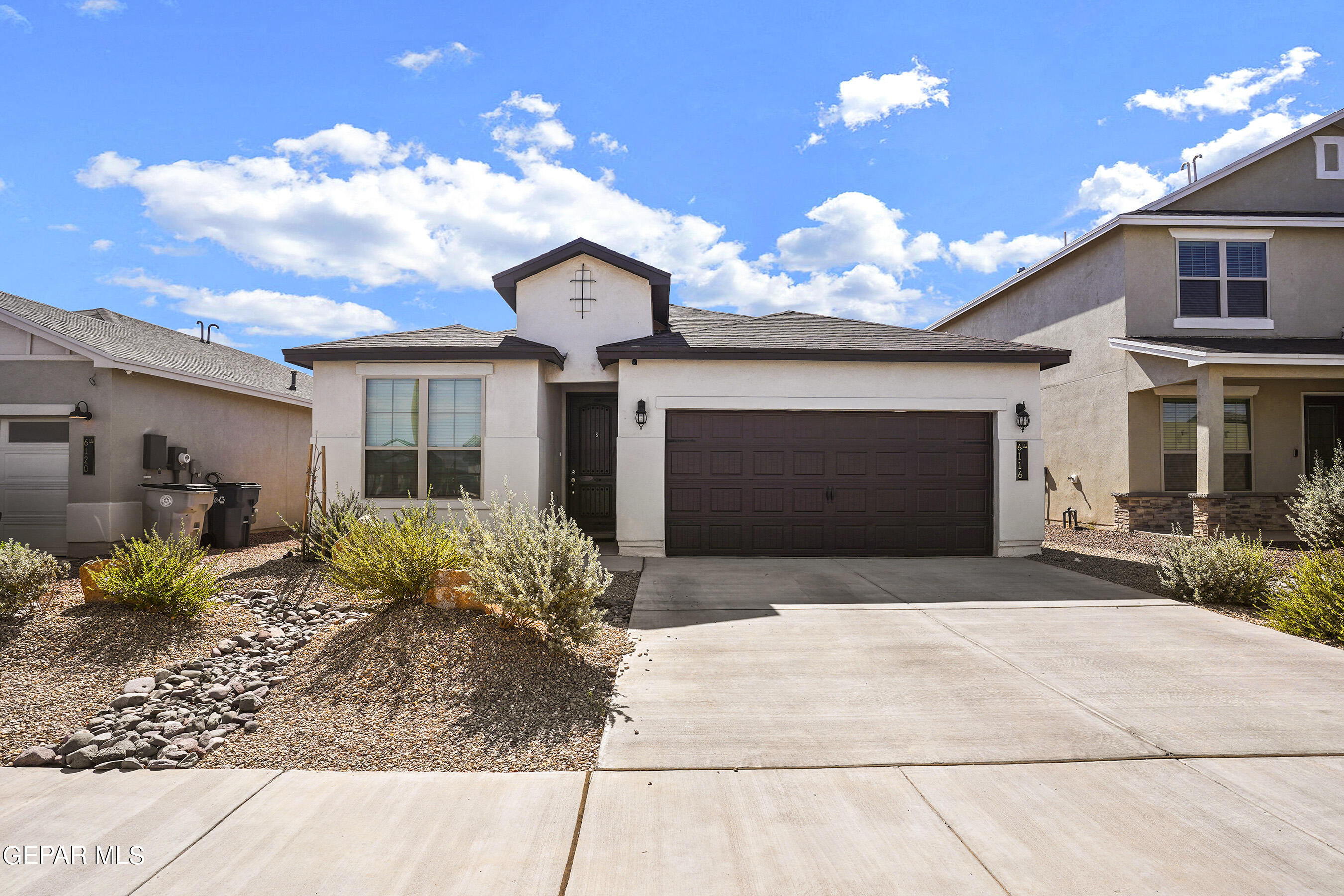 a front view of a house with a yard and a garage