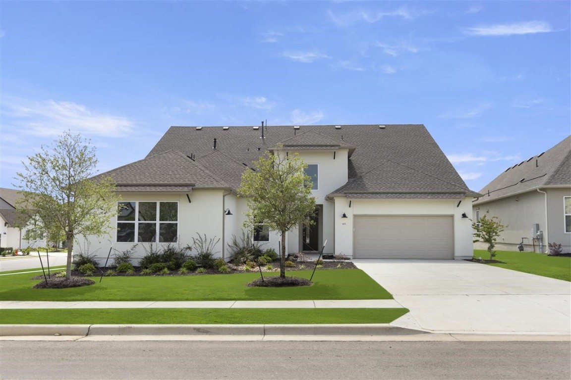 a front view of a house with a yard and garage