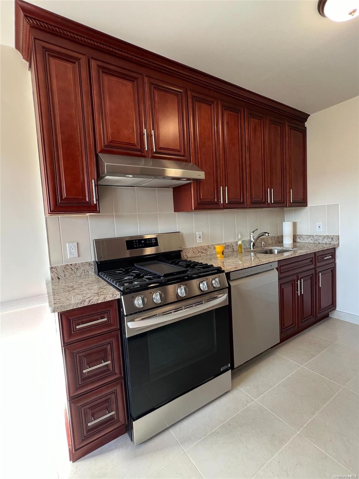 a kitchen with granite countertop wooden cabinets and stainless steel appliances