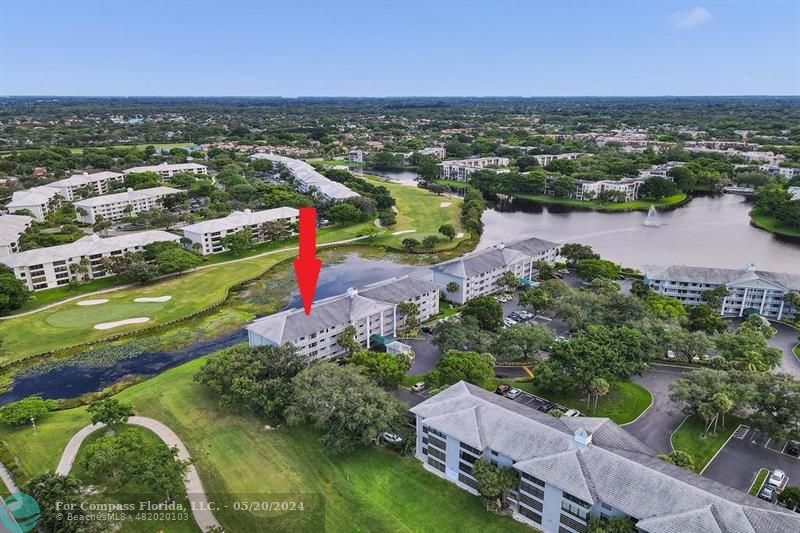 an aerial view of residential houses with outdoor space and lake view