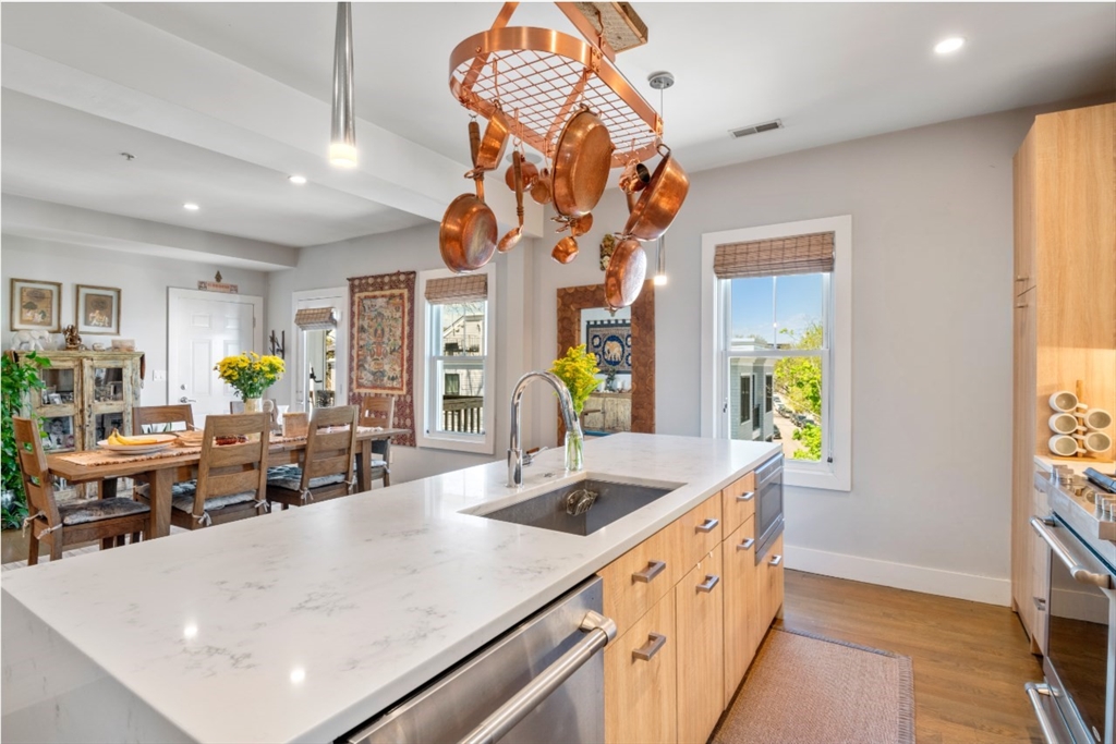 a kitchen with stainless steel appliances kitchen island granite countertop a sink a counter top space and living room view