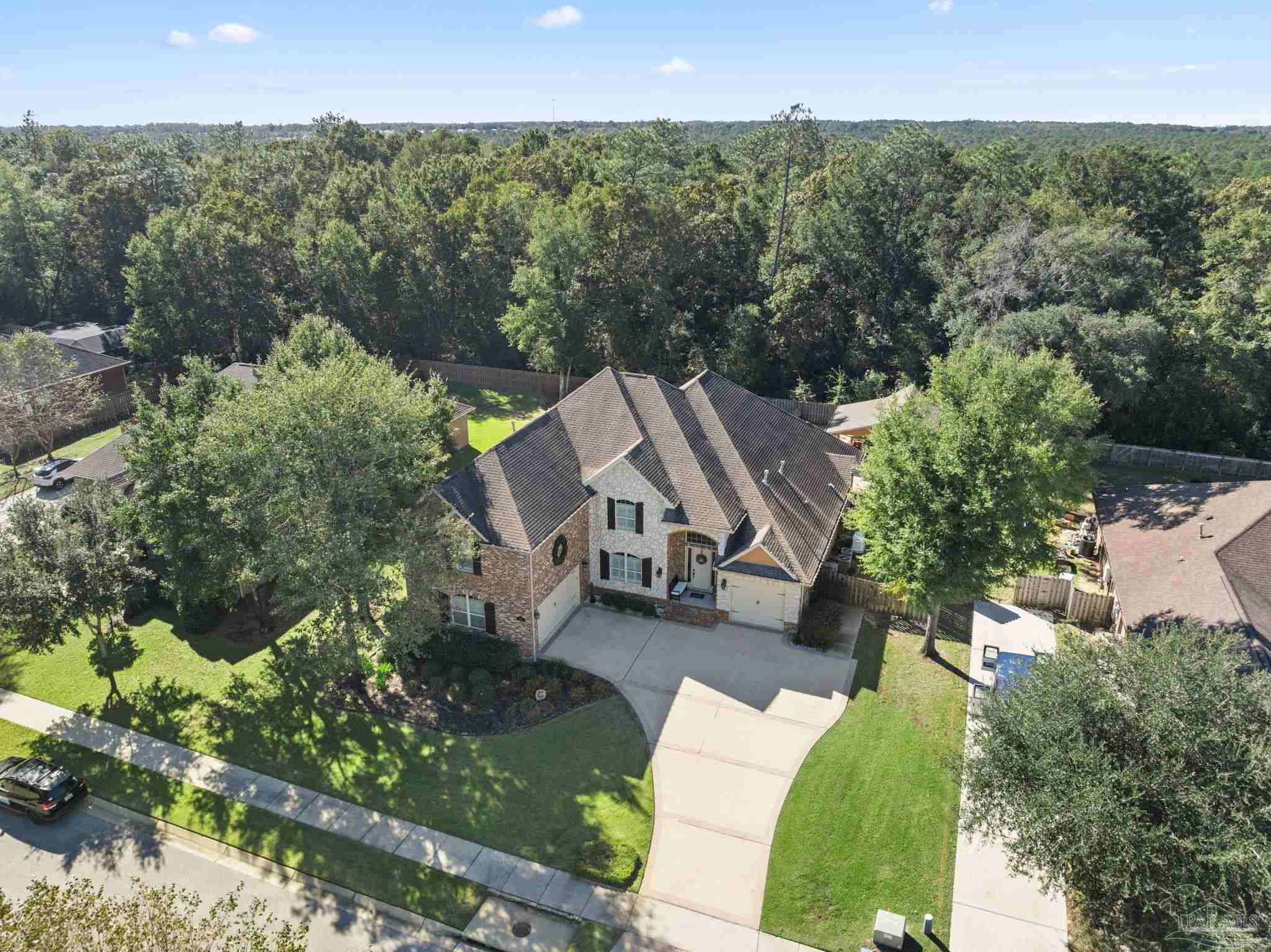 an aerial view of a house with a yard and lake