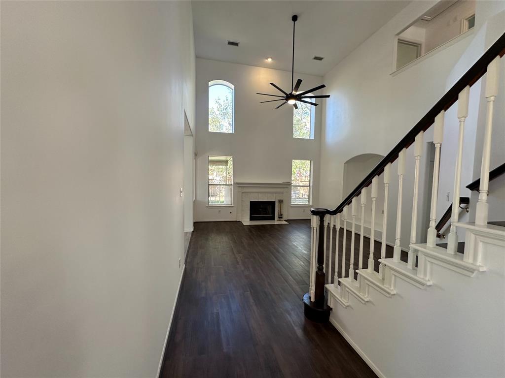 a view of a livingroom with wooden floor staircase and a kitchen