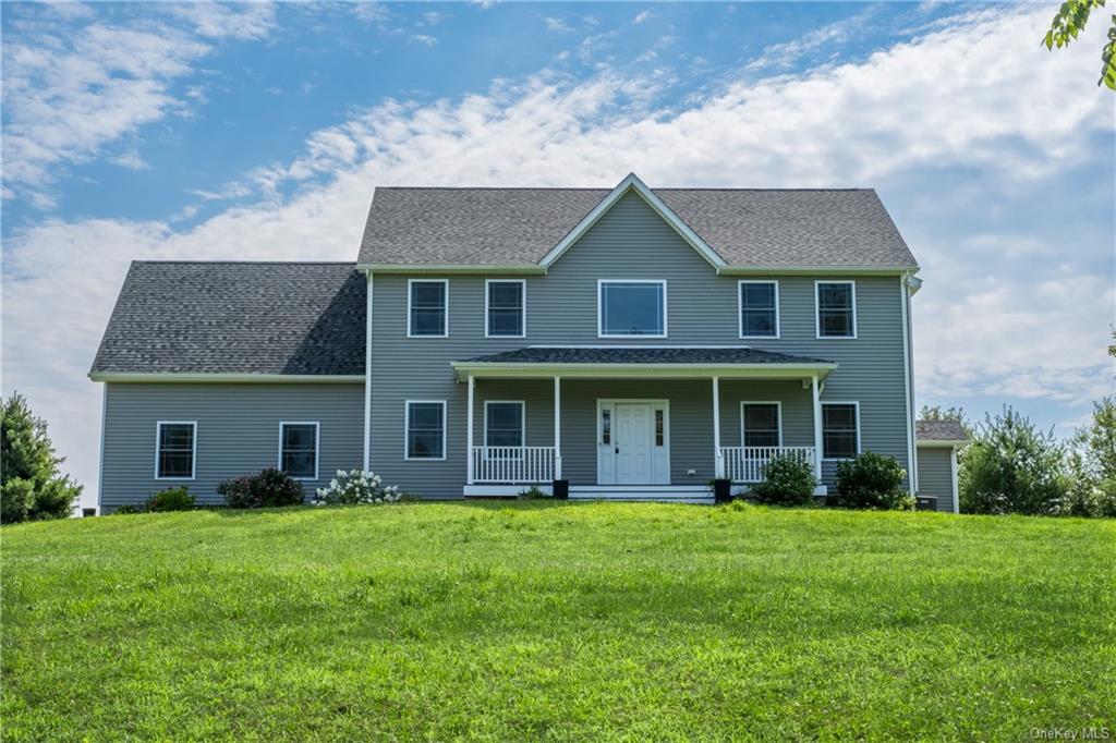 Colonial-style house with a front lawn and a porch