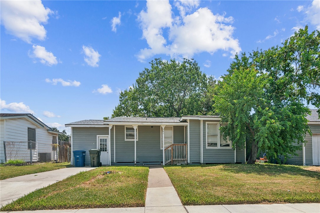 a front view of a house with a yard and trees