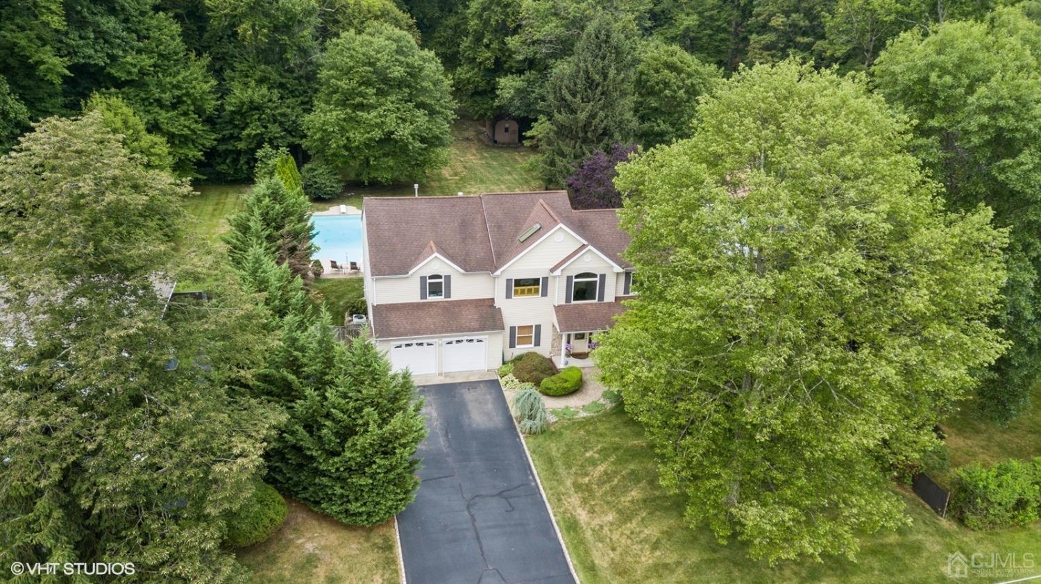 a aerial view of a house with a yard and large trees