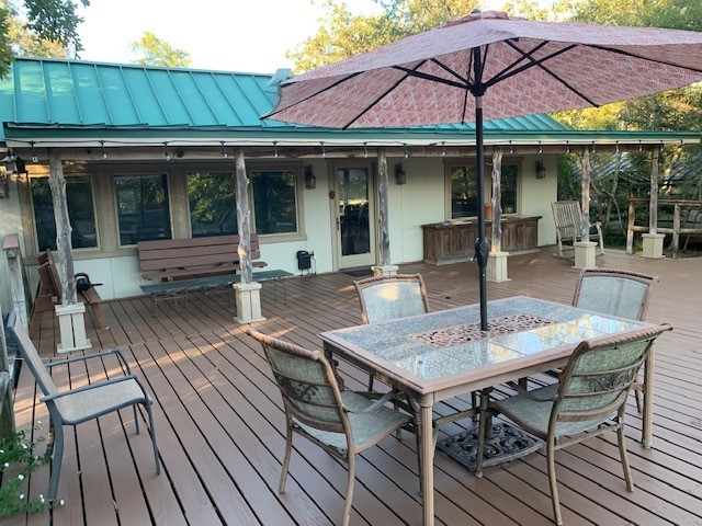 a view of house with wooden deck and outdoor seating