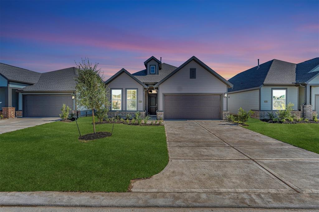 Charming single-story home with a modern exterior, featuring a two-car garage and neatly landscaped front yard.