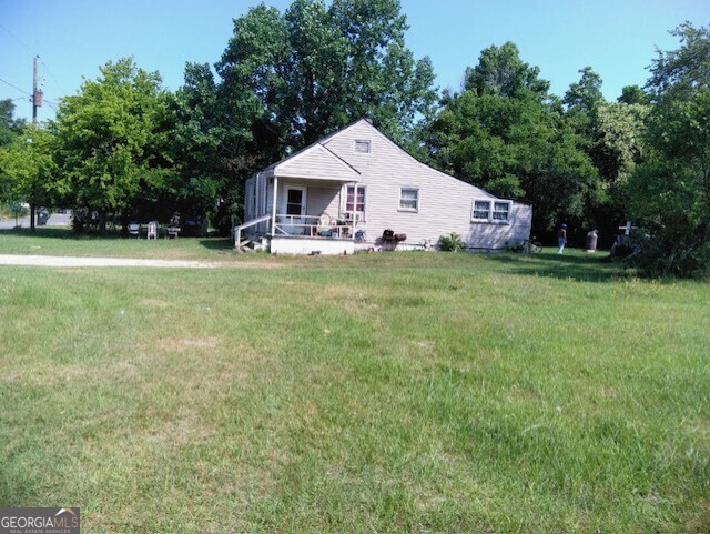 a front view of a house with a yard and trees