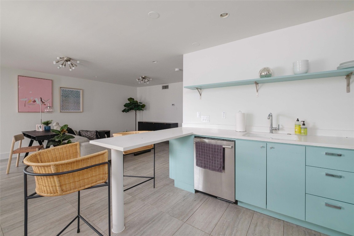 a kitchen with stainless steel appliances a stove a sink cabinets and wooden floor