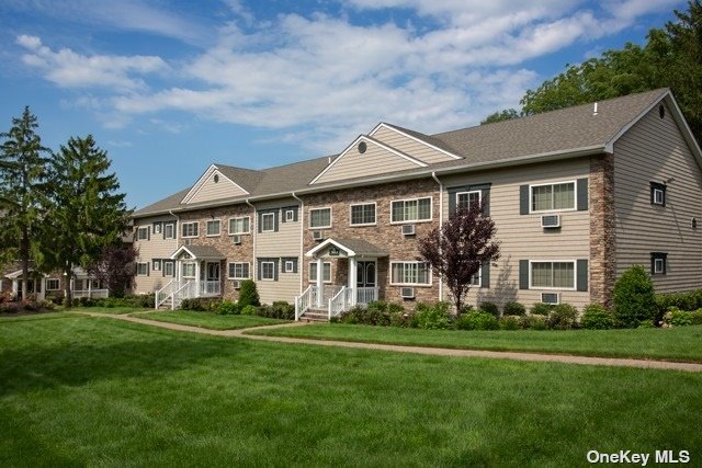 a front view of a house with a garden and trees