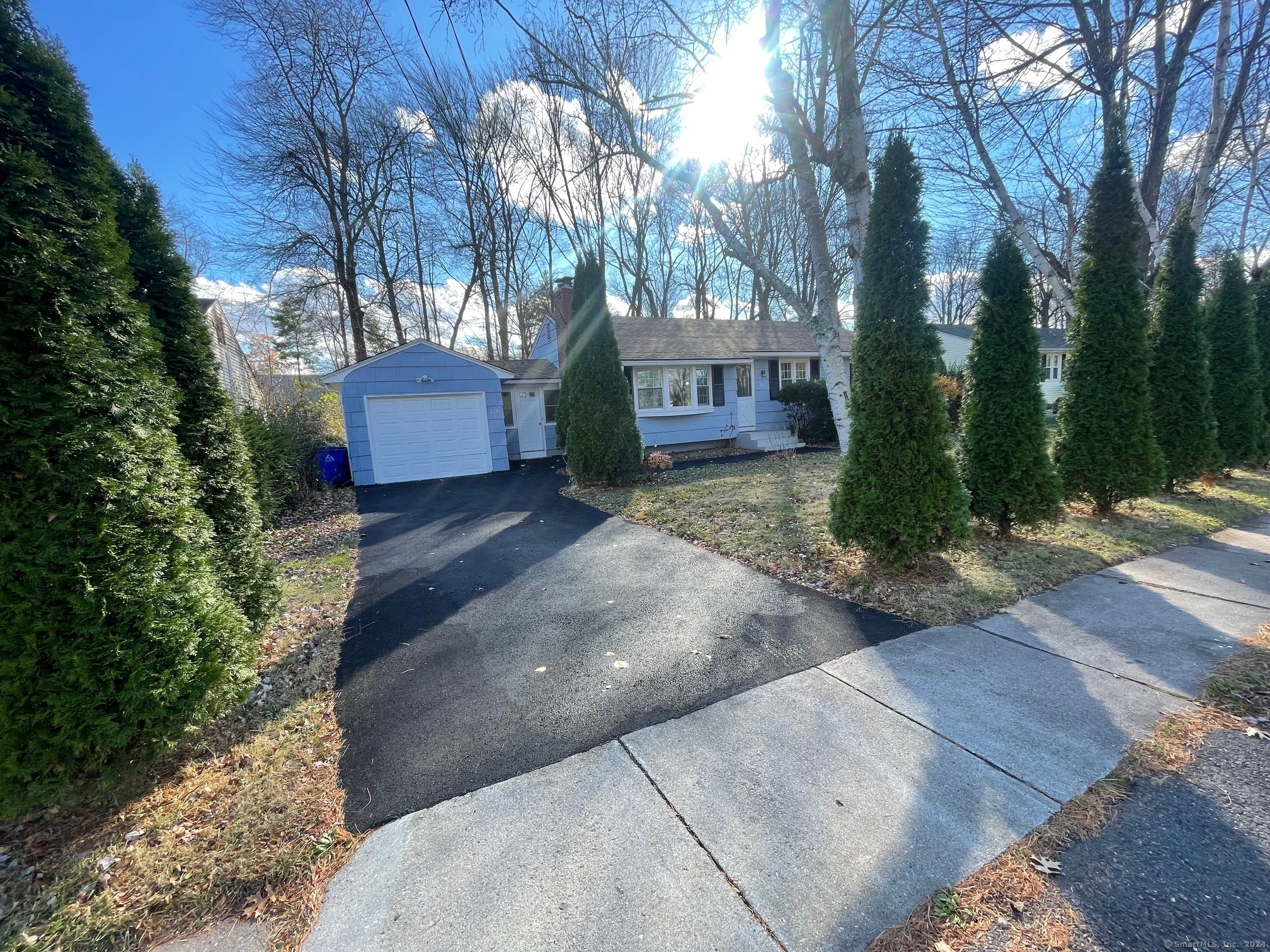 a front view of a house with a yard and tree s