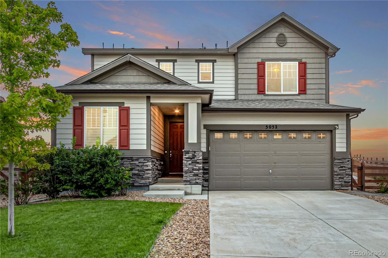 a front view of a house with a yard and garage