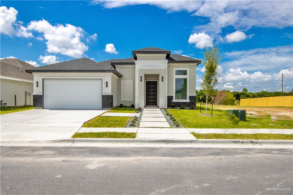 Prairie-style home with a garage and a front yard