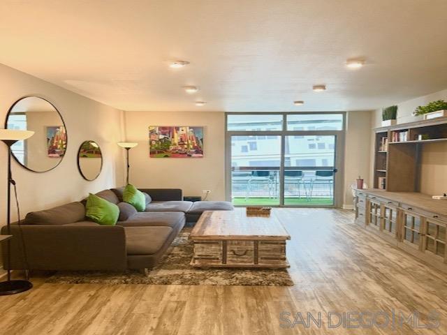 a living room with furniture a flat screen tv and a large window