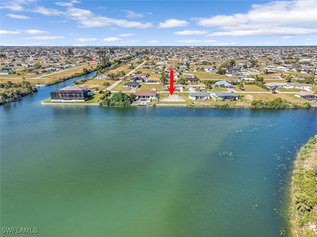 an aerial view of ocean and residential houses with outdoor space