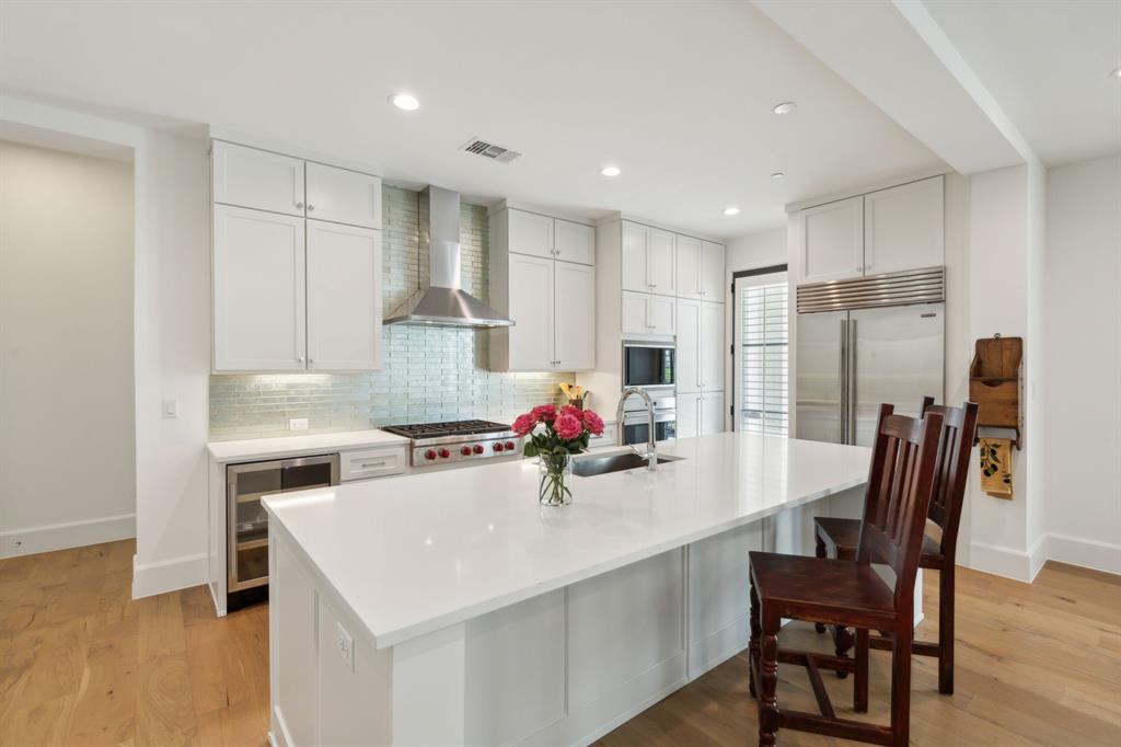 a kitchen with a dining table chairs and refrigerator