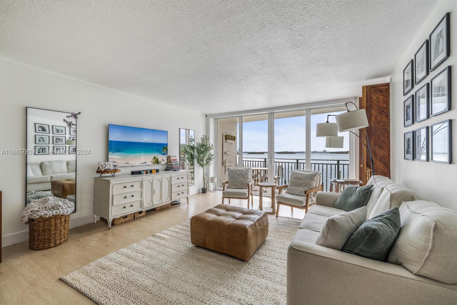 a living room with furniture flat screen tv and a large window