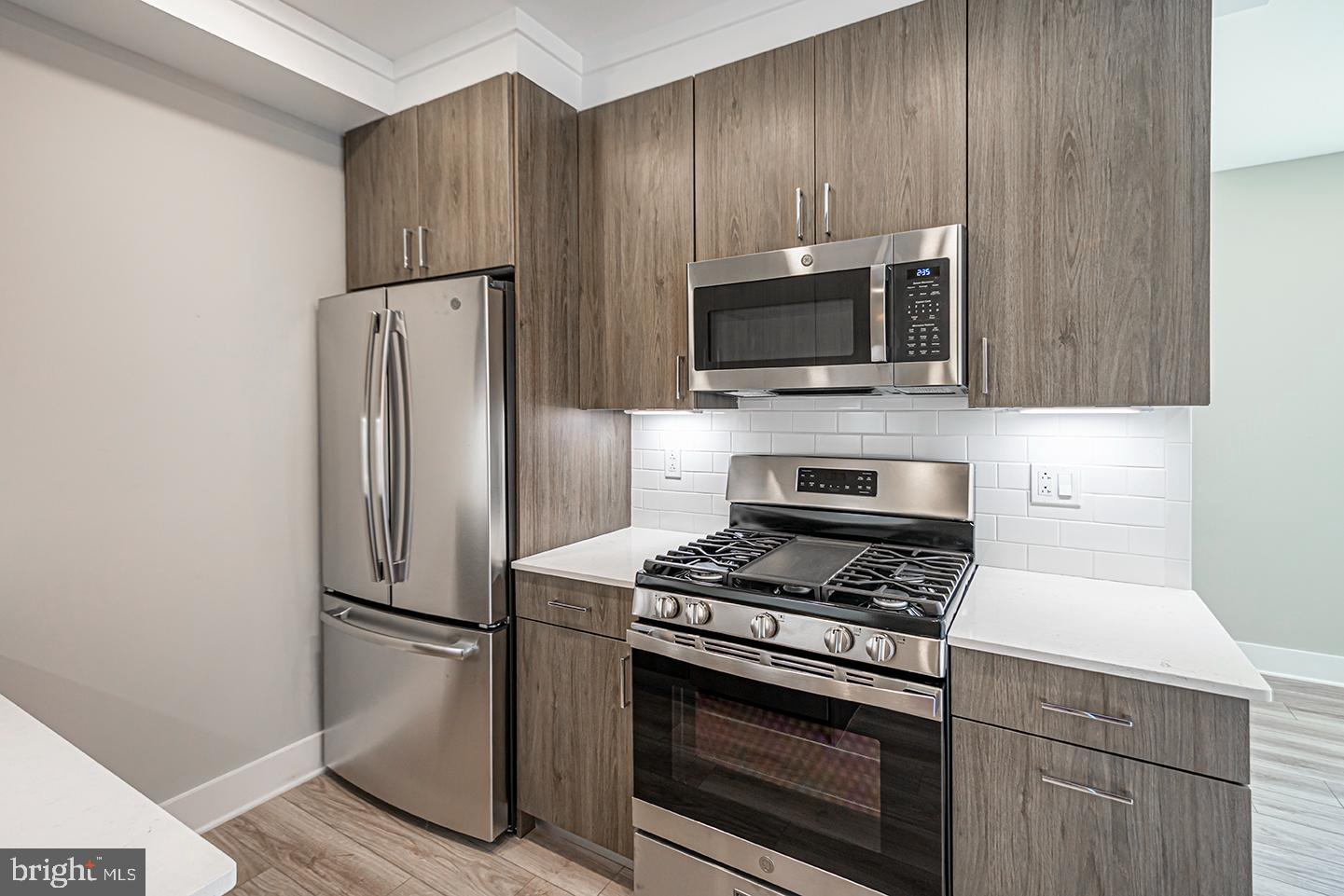 a kitchen with a refrigerator stove and microwave