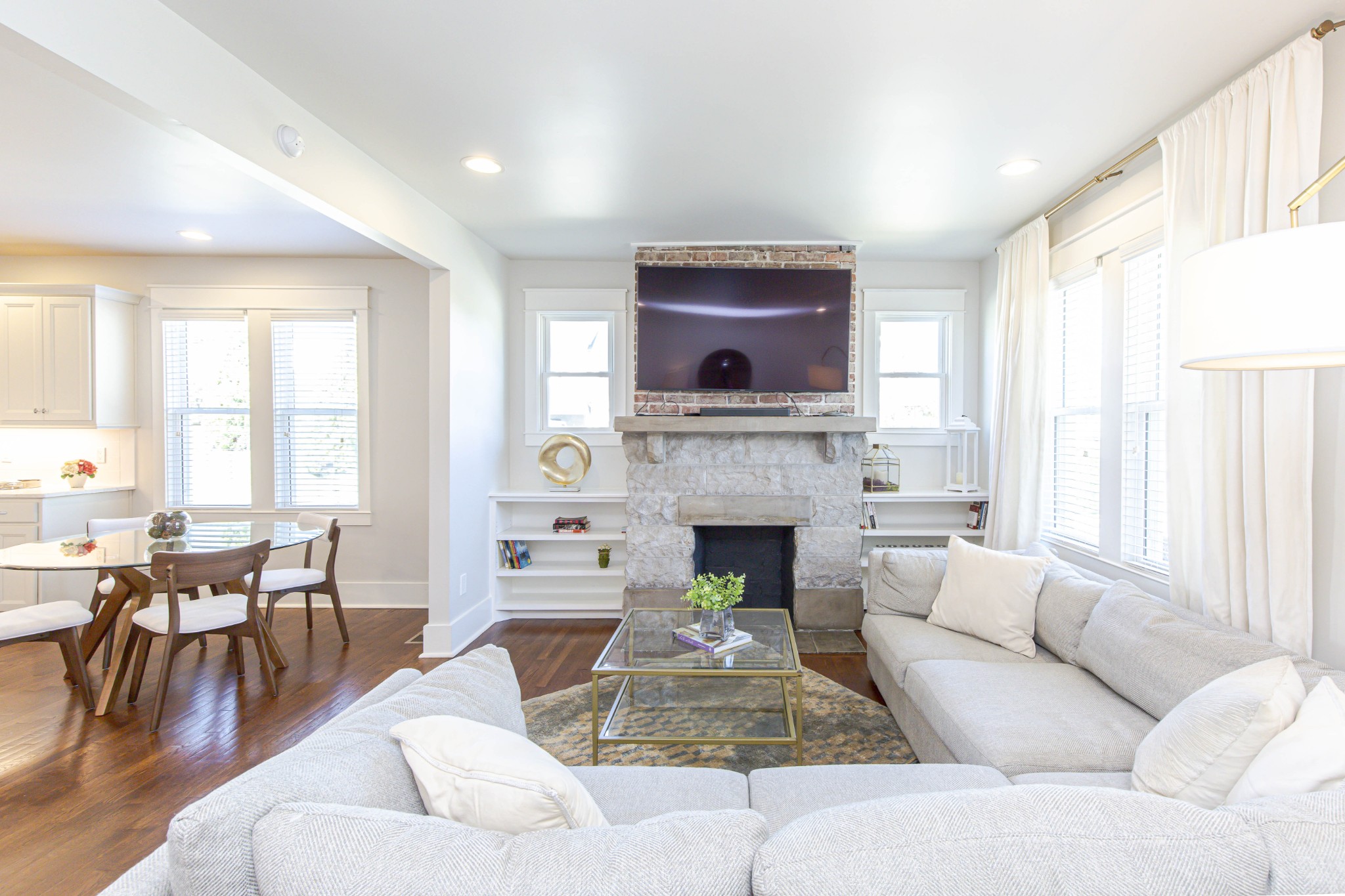 a living room with furniture a large window and a fireplace