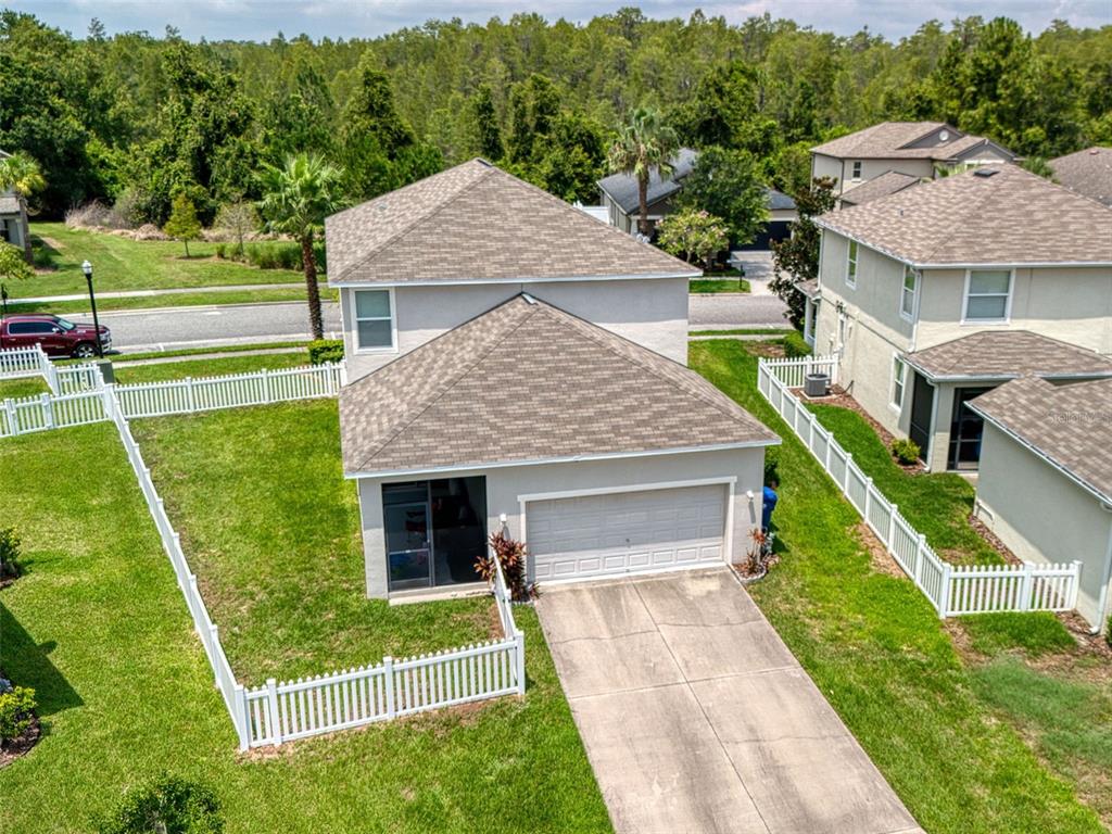 a aerial view of a house with a yard deck and furniture